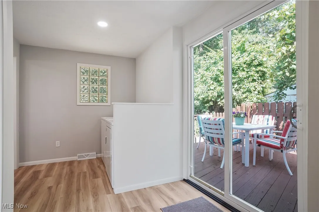 Laundry area featuring separate washer and dryer, light wood-style floors, and recessed lighting