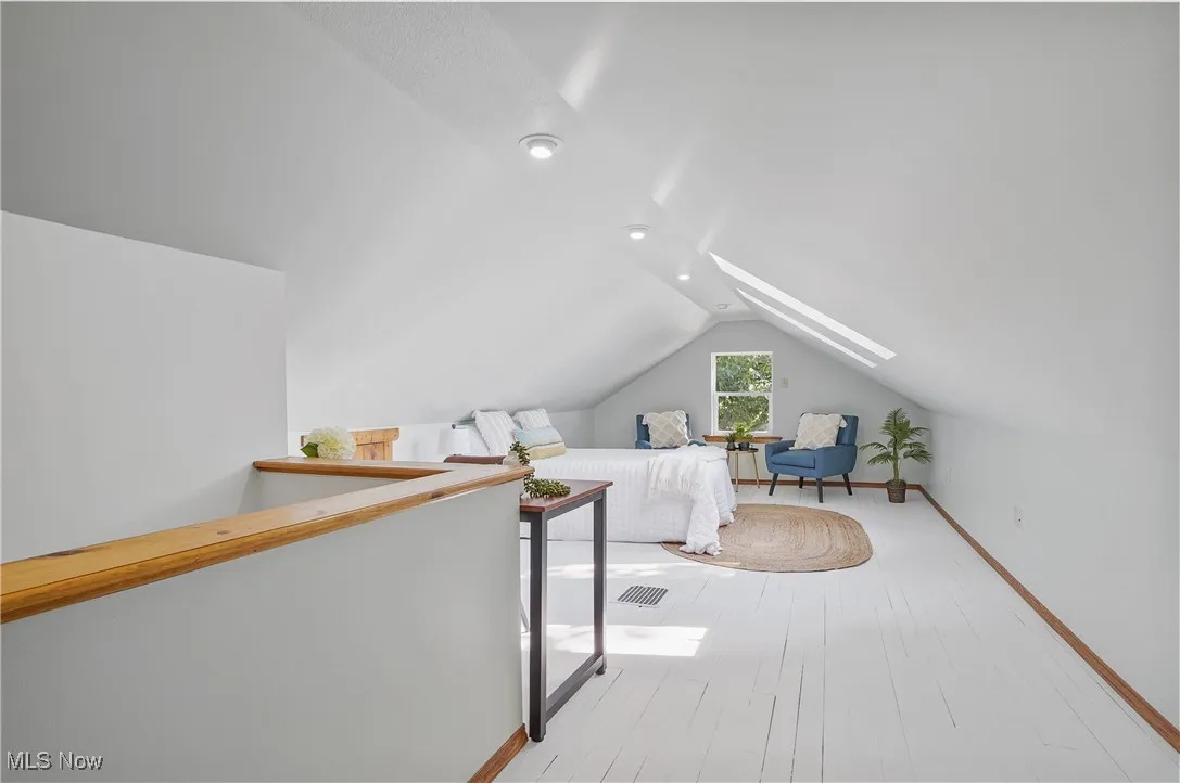 Bedroom with vaulted ceiling and light wood finished floors