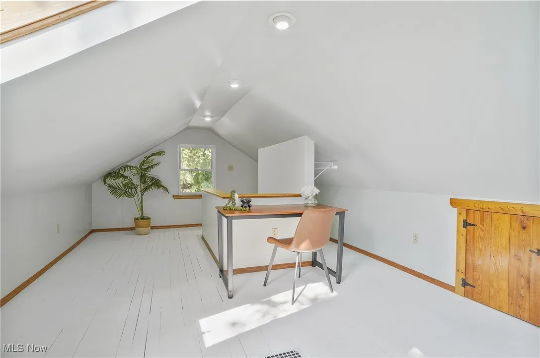 Office area with vaulted ceiling and wood finished floors