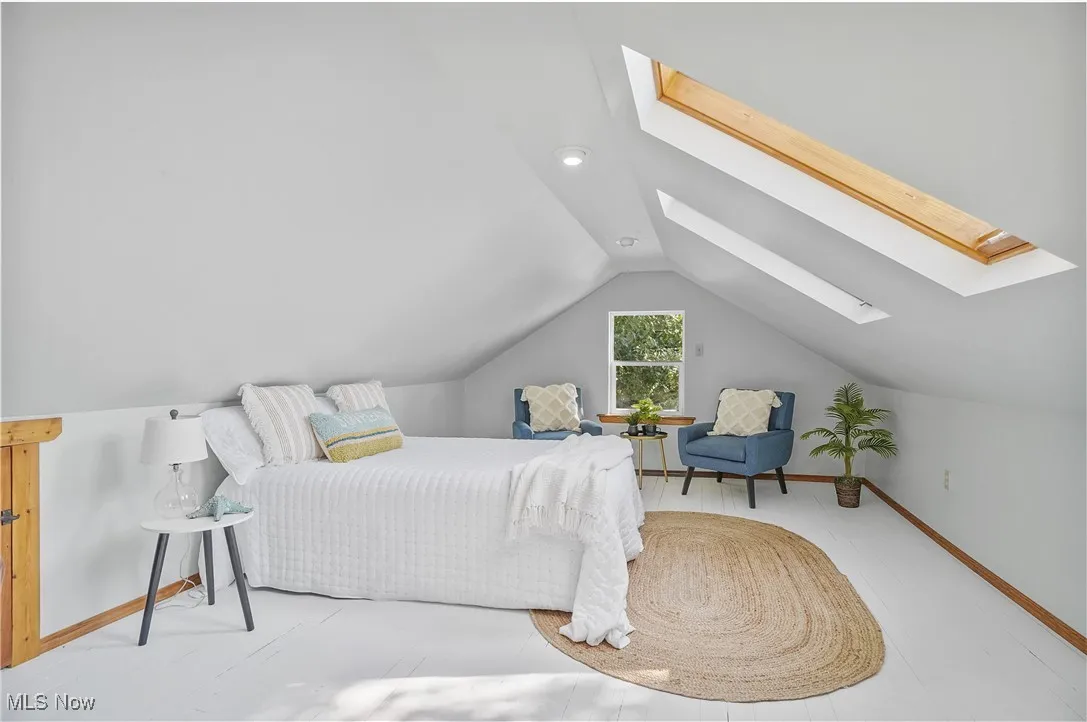Bedroom with a skylight and vaulted ceiling
