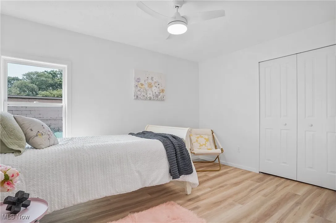 Bedroom featuring wood finished floors, a closet, and a ceiling fan