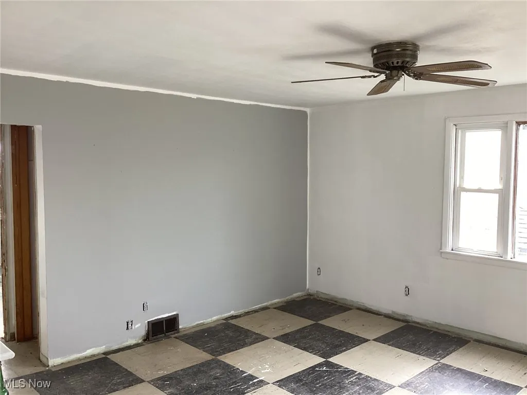 Unfurnished room featuring light floors and a ceiling fan