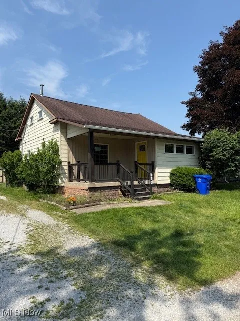 View of front of property featuring a porch and a front lawn