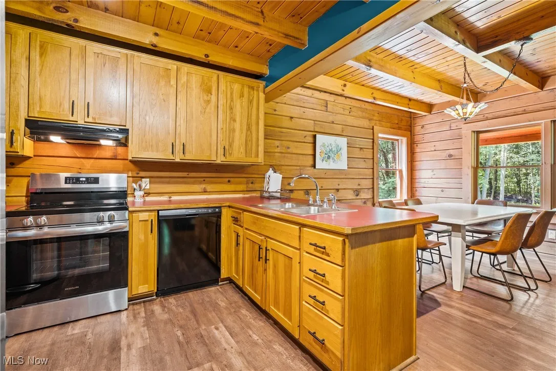 Kitchen with dishwasher, under cabinet range hood, stainless steel electric stove, a wood ceiling with exposed beams, and a peninsula
