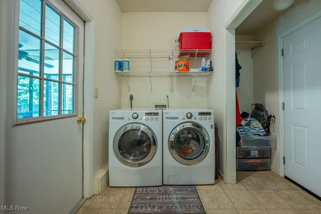 Washroom featuring washing machine and dryer and baseboards
