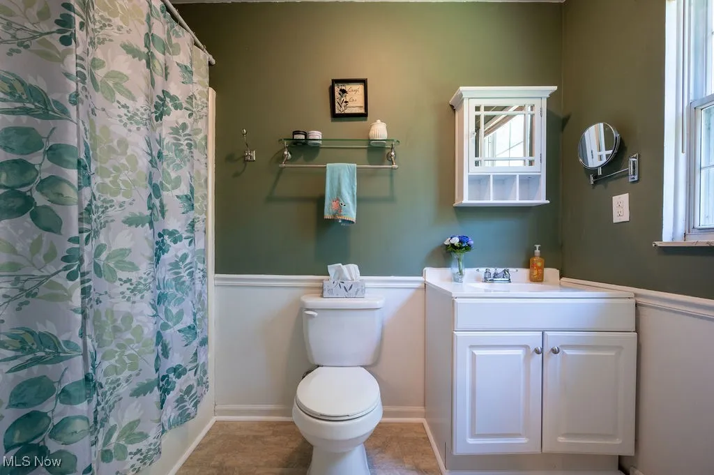 Full bathroom featuring vanity, curtained shower, and tile patterned floors