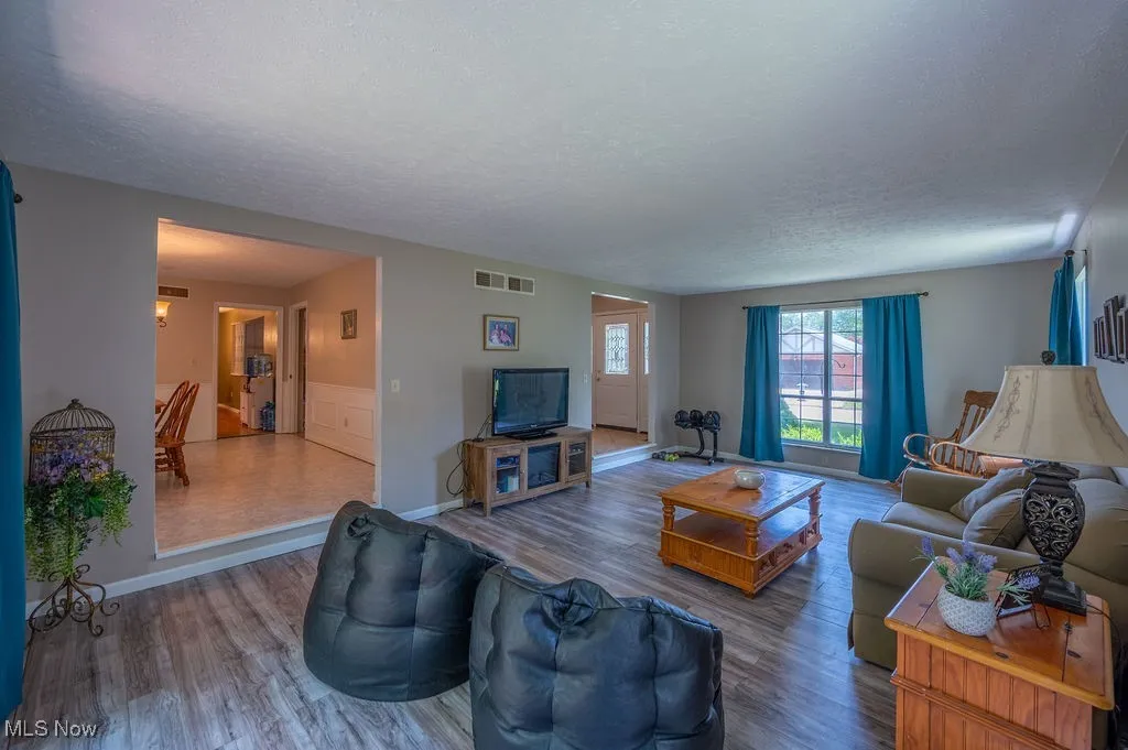Living area featuring wood finished floors and a textured ceiling