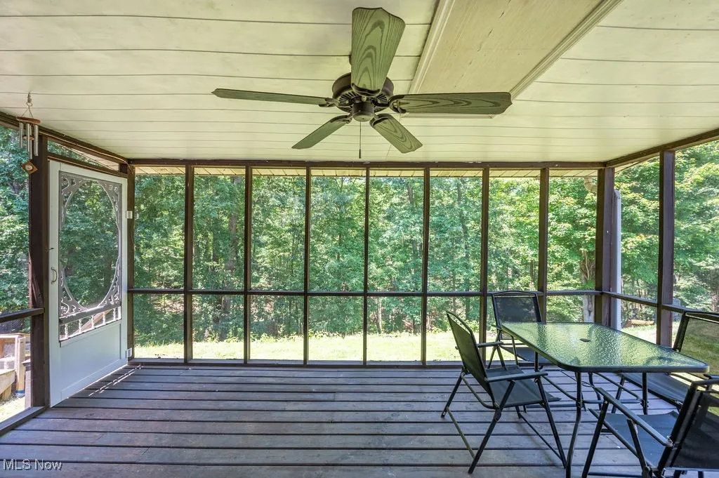 Sunroom featuring ceiling fan and outdoor dining space