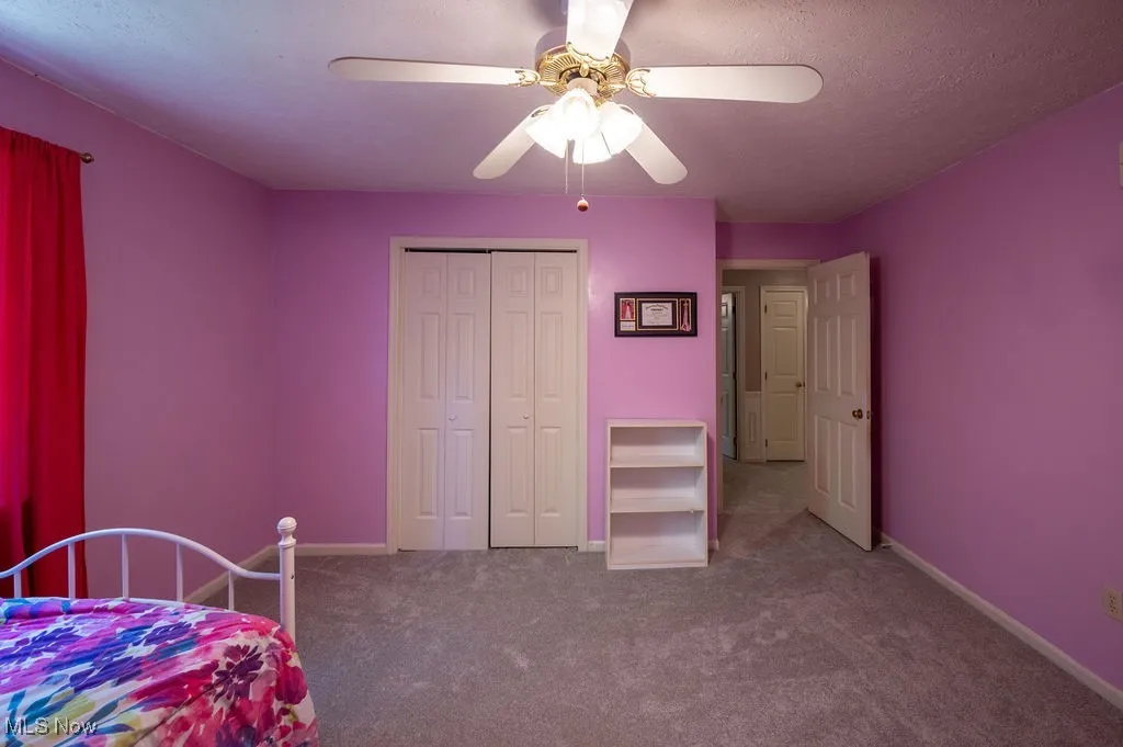 Bedroom with carpet flooring, a closet, and a ceiling fan