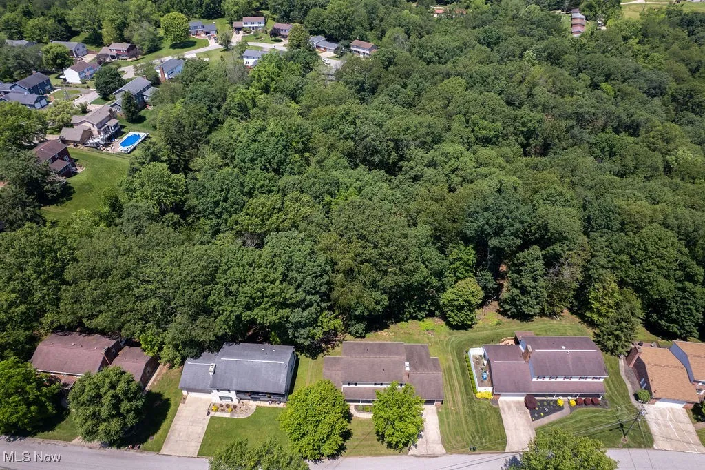 Aerial view of property and surrounding area with nearby suburban area