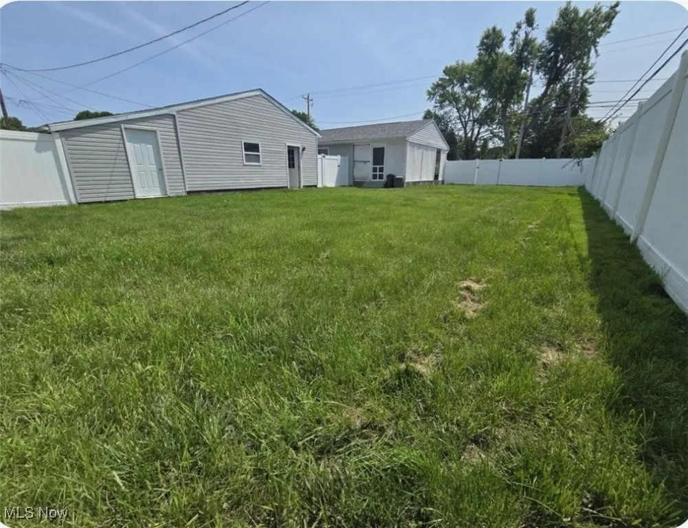 Fenced backyard with an outbuilding
