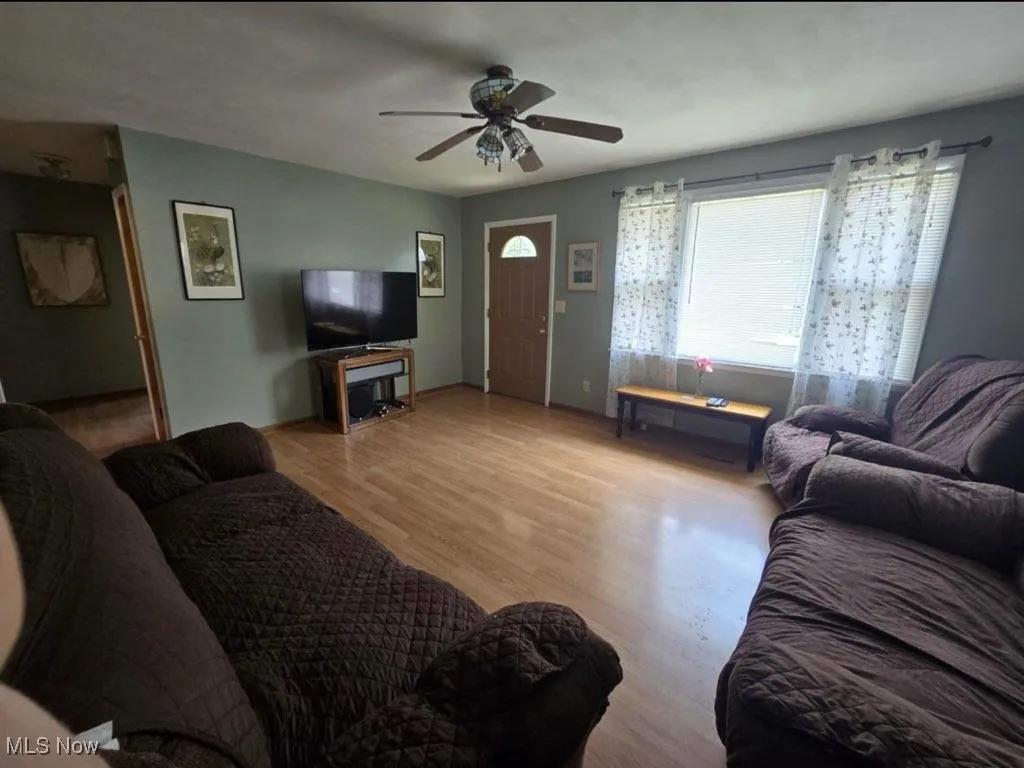 Living room featuring ceiling fan and light wood-style floors
