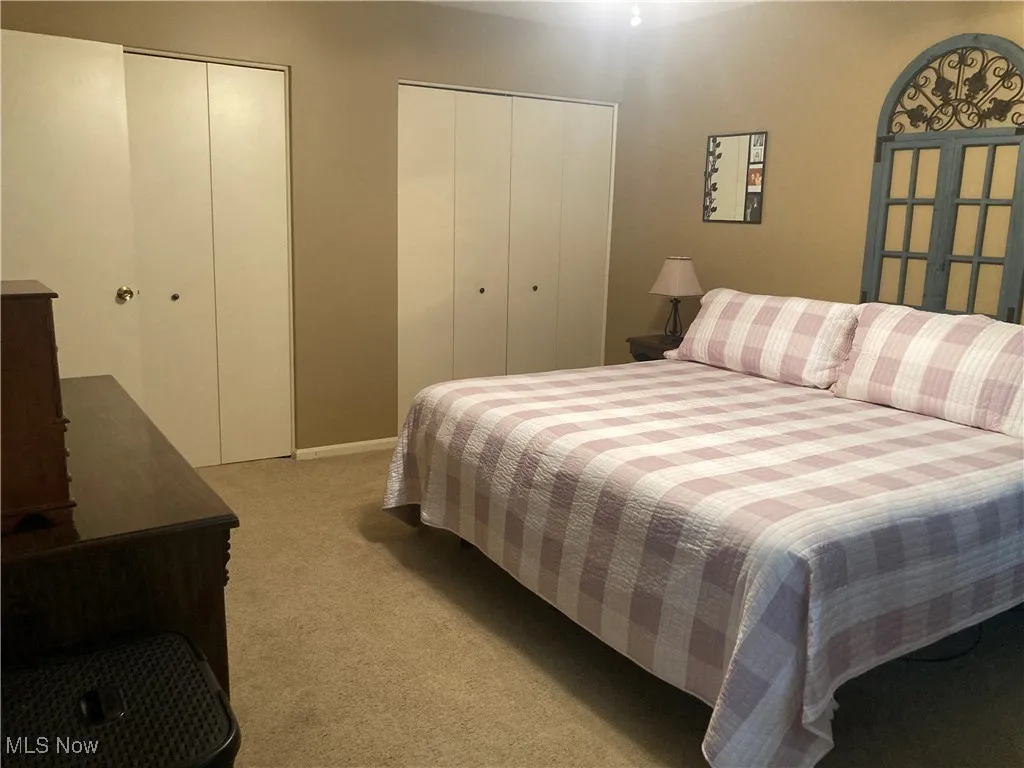 Bedroom featuring multiple closets and light colored carpet