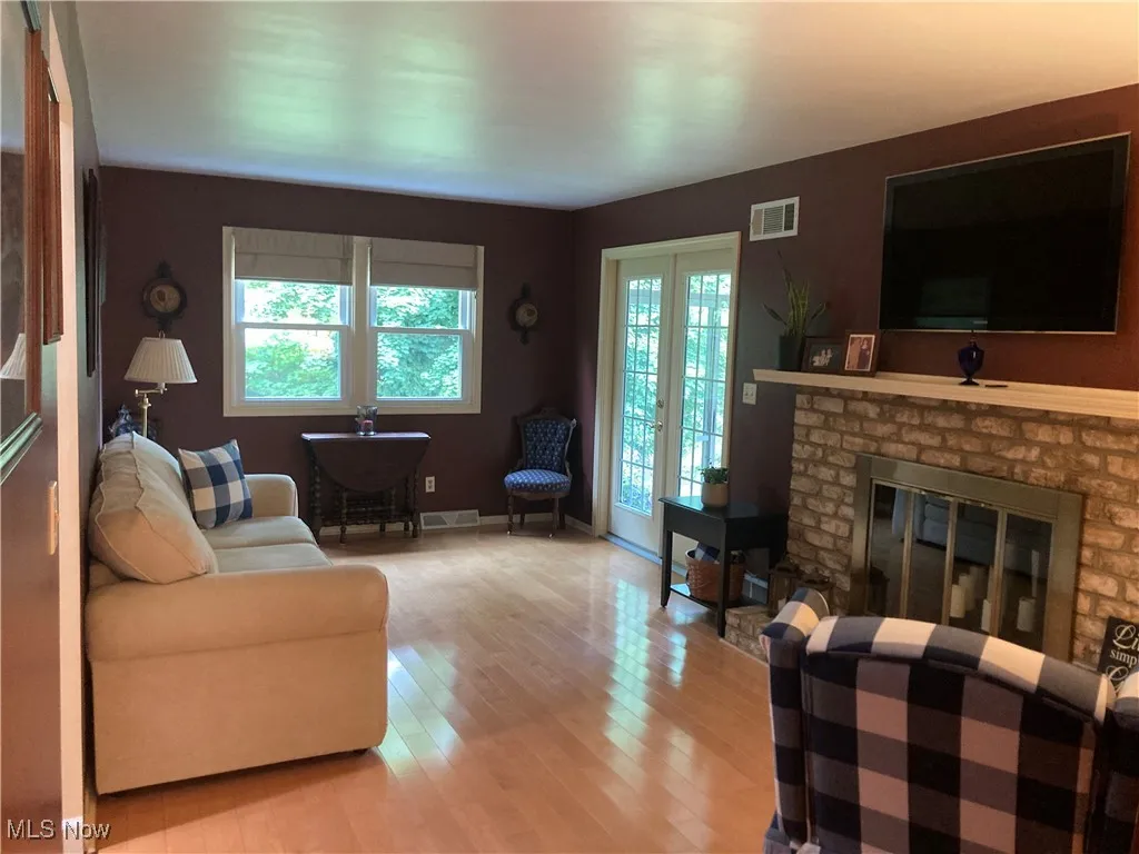 Living room with light wood finished floors and a brick fireplace
