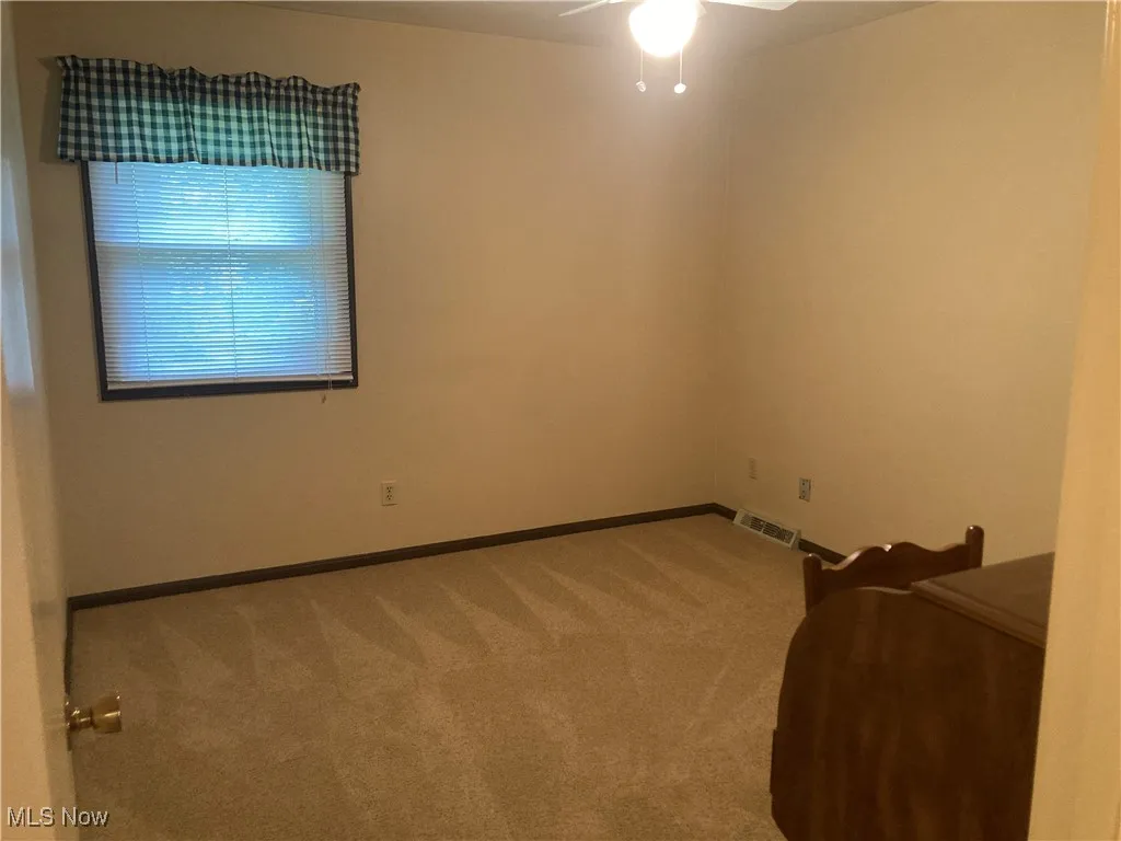 Spare room featuring ceiling fan and carpet