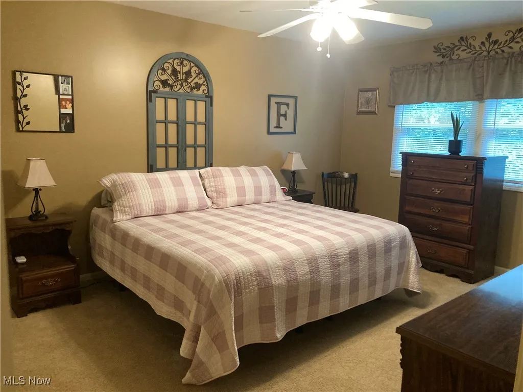 Bedroom featuring light colored carpet and a ceiling fan