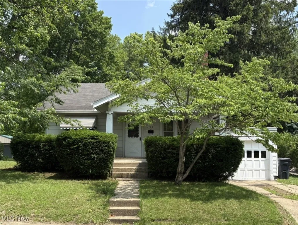 View of property elements featuring a front lawn and a garage