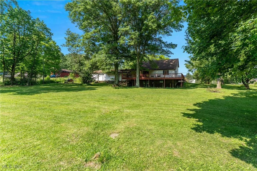 View of grassy yard with a deck