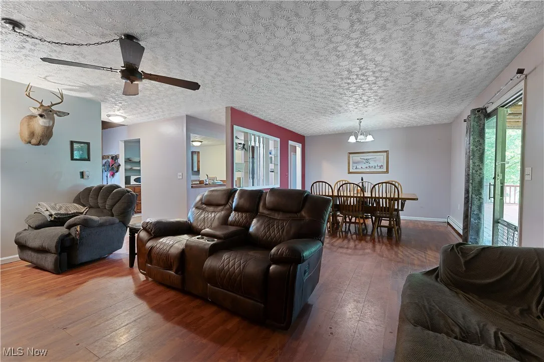 Living area with  wood-style flooring, a chandelier,  and ceiling fan