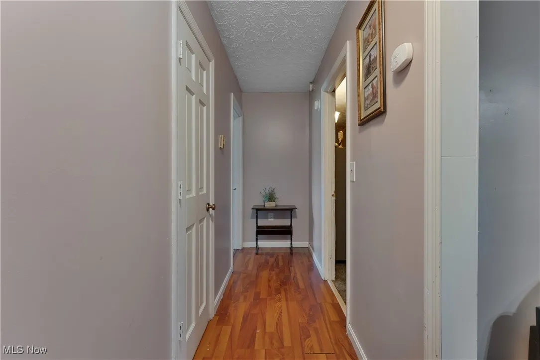 Hallway leading to 1st floor primary and 1st floor full bath
