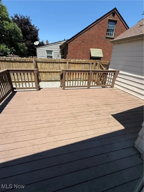 Wooden deck with a fenced backyard