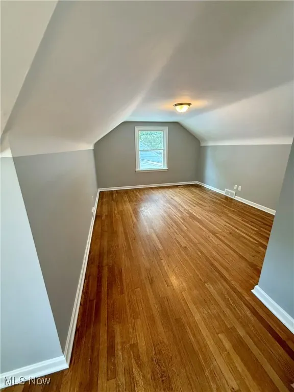 Bonus room featuring wood-type flooring and vaulted ceiling
