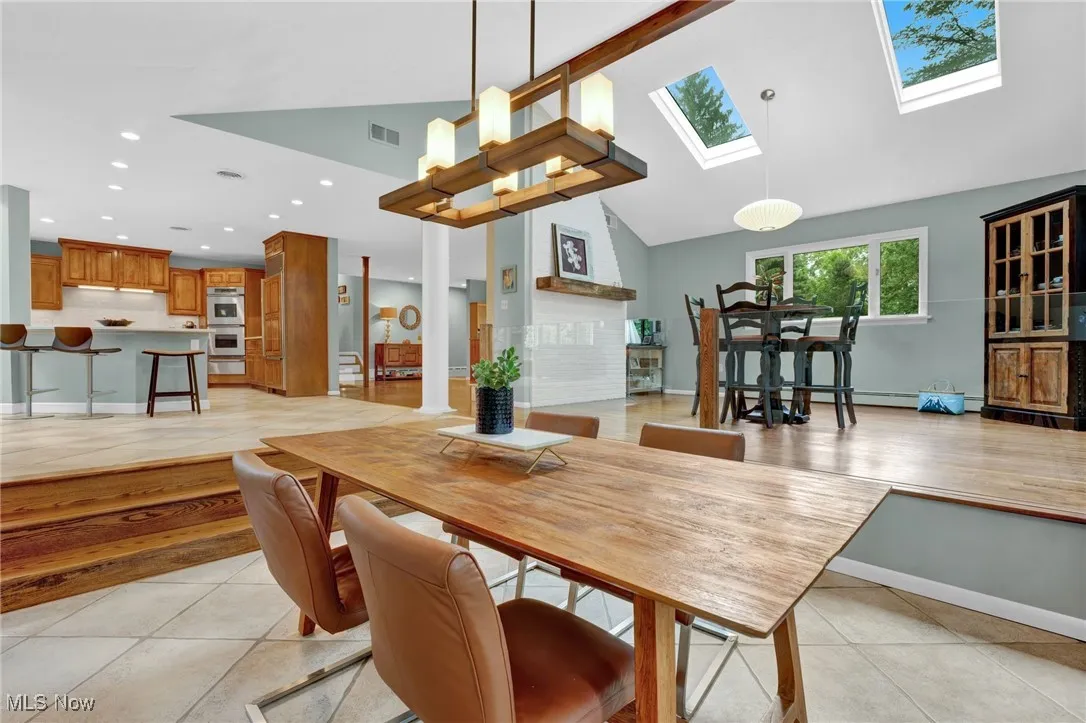 Step down to a cozy, open dining area with nearby 2 skylights, clean sightlines, unique/custom chandelier. Hosting parties with multiple dining and entertaining areas, with are both open yet distinct provides the perfect blend of casual, informal dining as well as hosting big family get-togethers.