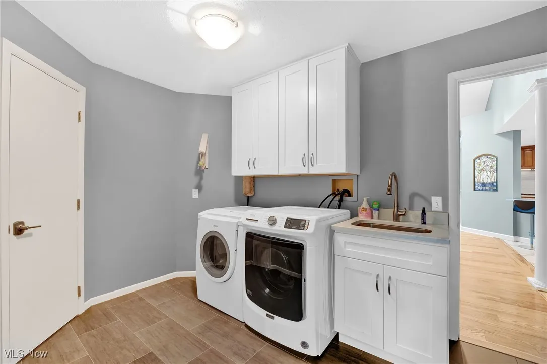 Calling this simply a laundry room is a disservice for this fabulously reimagined, redesigned and renovated space. The porcelain floors are exceptional. The built-ins and open shelving above are custom designed for the space along with accent track lighting. A high-end built-in cabinet/sink and a hanging rack. Across from the built-ins is a cleverly designed open shelving pantry,  as you can never have enough storage space, even though the kitchen has an abundance of high-quality cabinetry. Door leads into the rear primary ensuite bath.