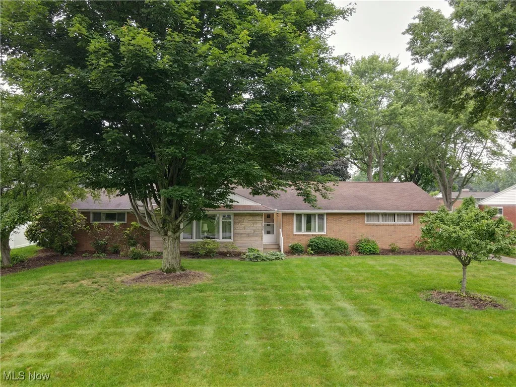 View of front facade featuring brick siding and a front lawn