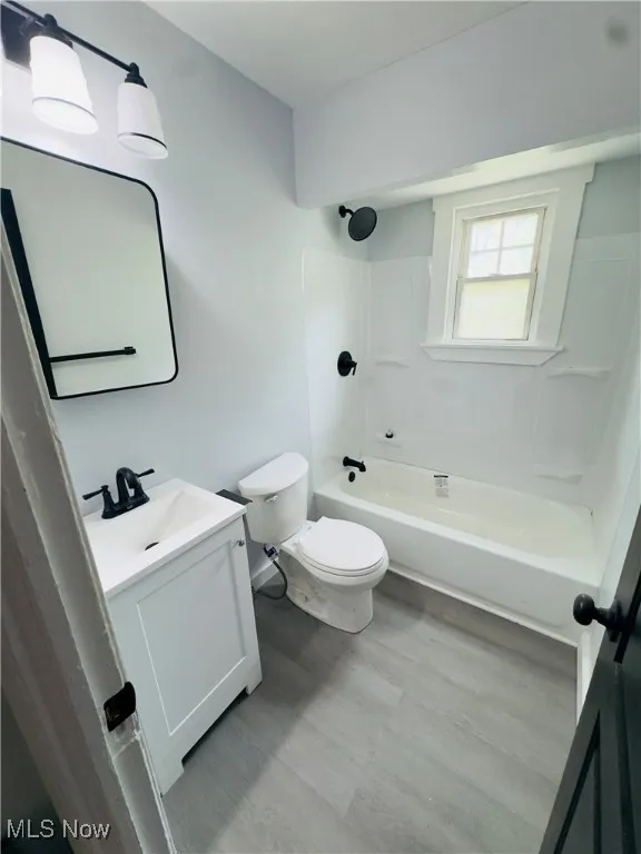Bathroom featuring vanity, wood finished floors, and shower / bath combination