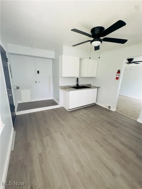 Unfurnished living room featuring ceiling fan and wood finished floors