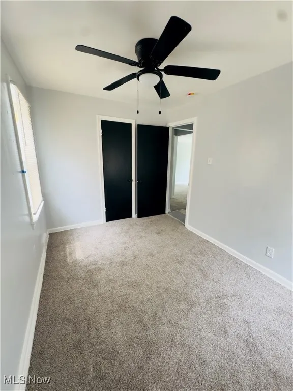Unfurnished bedroom with carpet flooring and ceiling fan