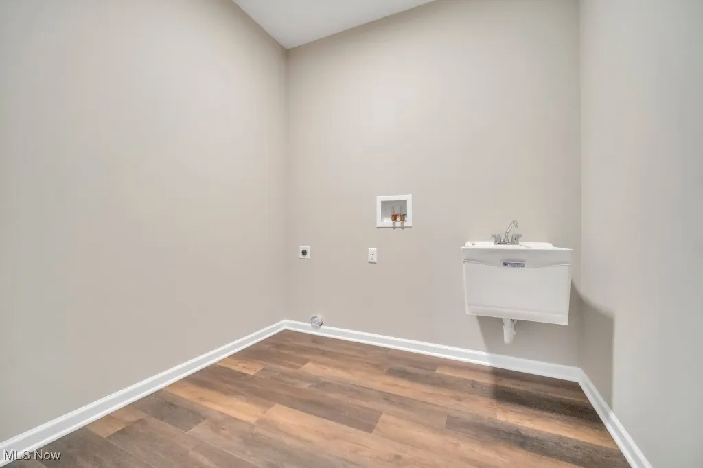 Washroom featuring hookup for an electric dryer, washer hookup, and dark wood finished floors