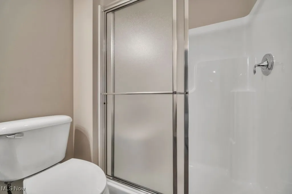 Bathroom with a shower stall and toilet