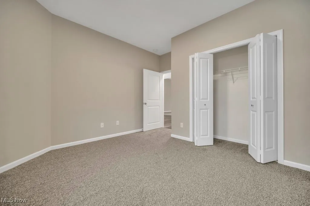 Unfurnished bedroom with carpet flooring and a closet