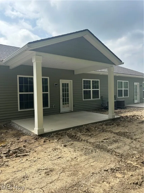 Back of property featuring a patio and a shingled roof