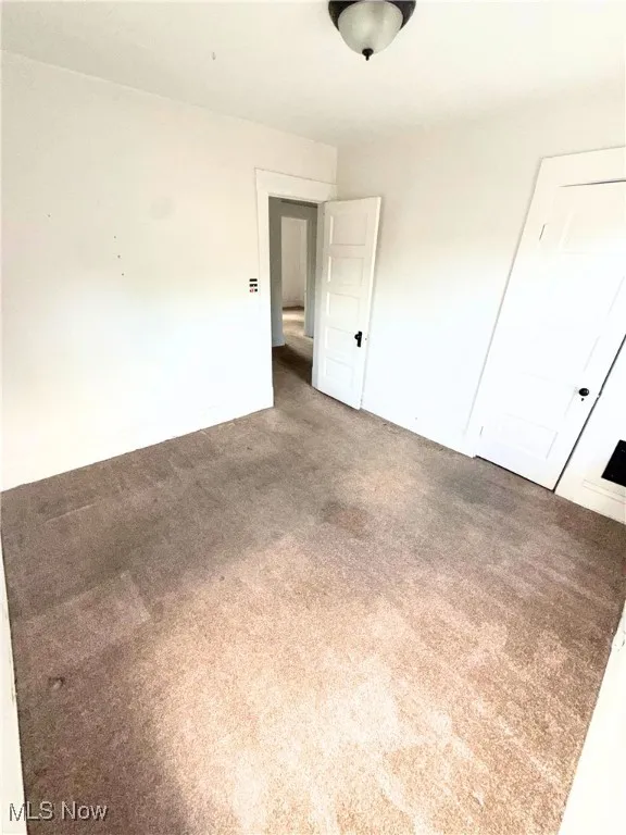 Unfurnished bedroom featuring carpet flooring and baseboards