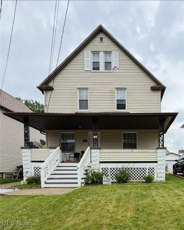 View of front of house with covered porch and a front yard