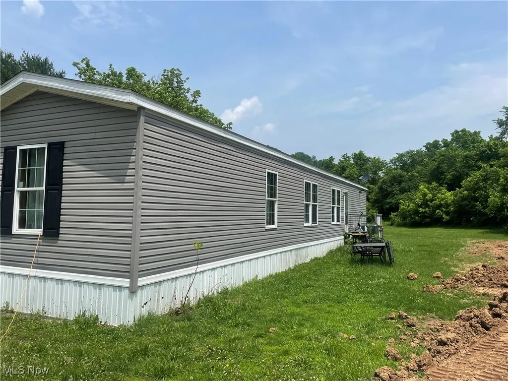 View of property exterior with a lawn
