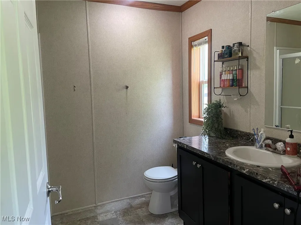 Bathroom featuring vanity and a shower with door