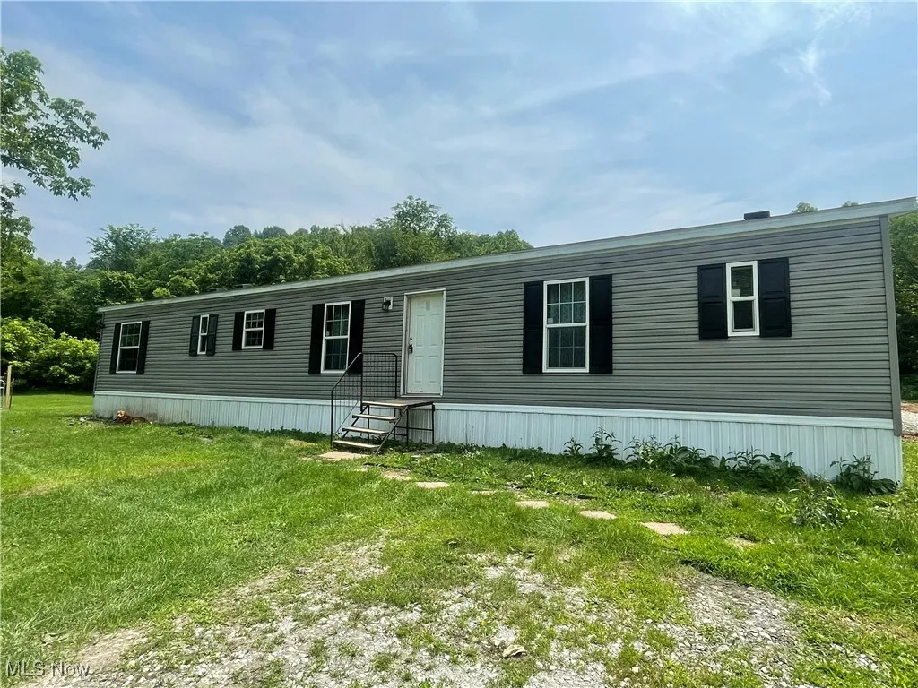 Manufactured / mobile home with entry steps and a front yard