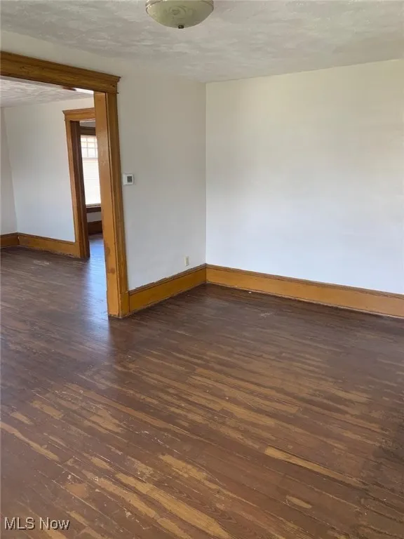 Empty room featuring hardwood / wood-style flooring and a textured ceiling