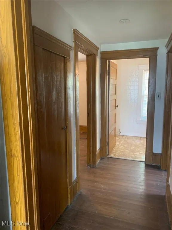 Hall featuring hardwood / wood-style flooring and baseboards