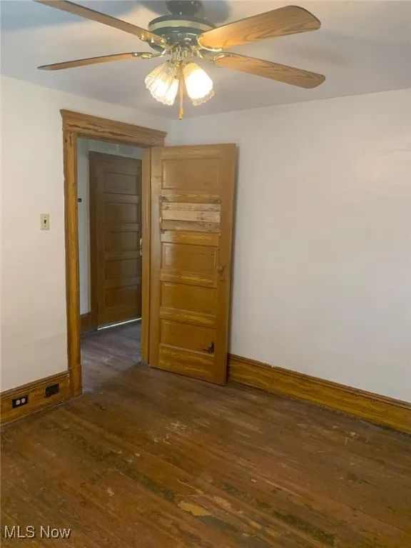 Spare room featuring ceiling fan and dark wood finished floors