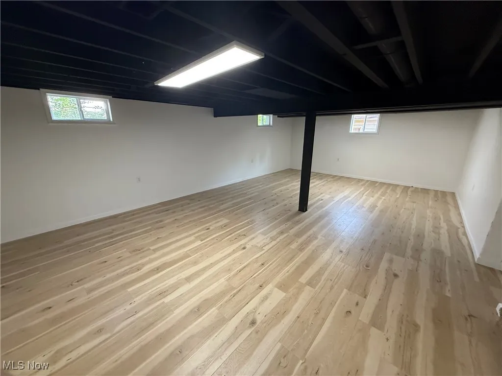 Basement with wood finished floors and plenty of natural light
