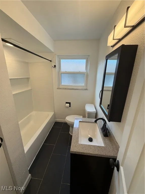 Bathroom featuring tile patterned floors, vanity, and shower / washtub combination
