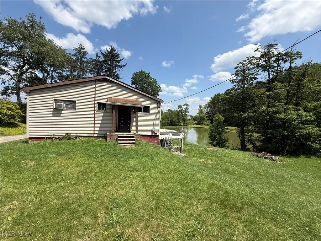 View of front of house with a front yard and a water view