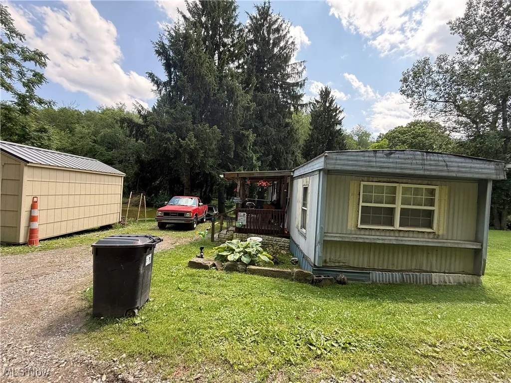 View of grassy yard featuring an outbuilding