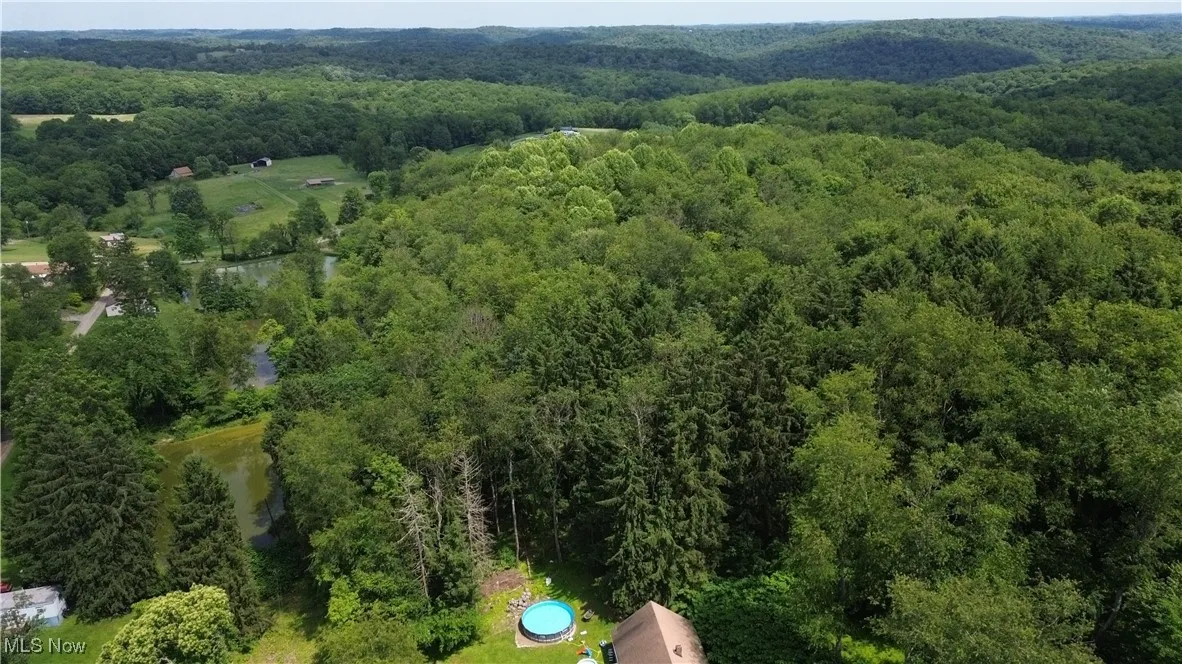 Aerial view of property's location featuring a heavily wooded area