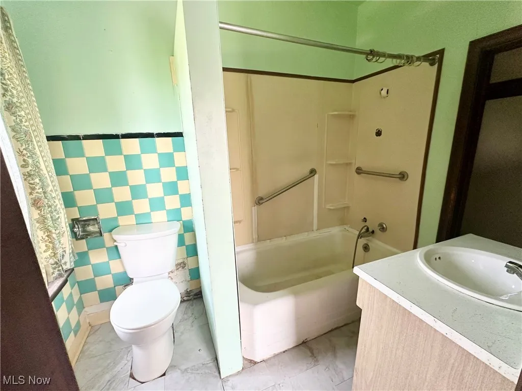 Bathroom with shower / bath combination, vanity, and toilet